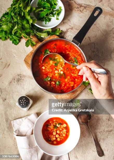 moroccan soup with chickpeas. woman cook pouring hot soup from saucepan into bowl - woman cook foto e immagini stock
