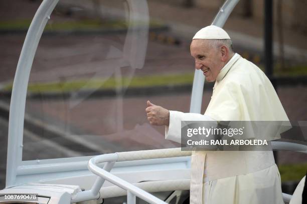 Pope Francis waves to the crowd of faithful from the popemobile, after landing at Panama's Tocumen International Airport on January 23, 2019. Pope...