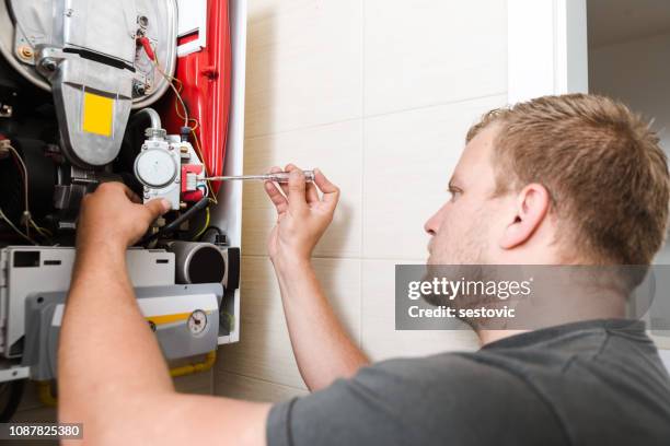 technician repairing gas furnace - electric heater home stock pictures, royalty-free photos & images