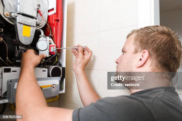 technician repairing gas furnace - furnace stock pictures, royalty-free photos & images