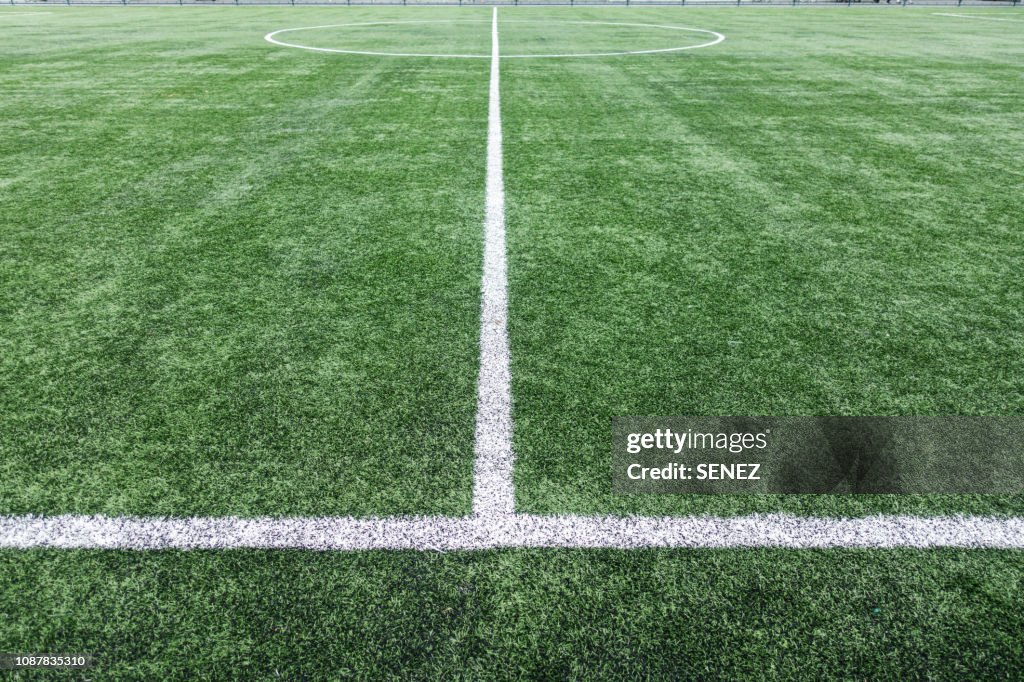 Look at the football field through the barbed wire