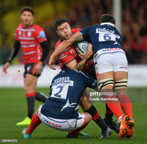 Matt Banahan of Gloucester is tackled by Rob Webber and Jonathan Ross of Sale Sharks during the Gallagher Premiership Rugby match between Gloucester...