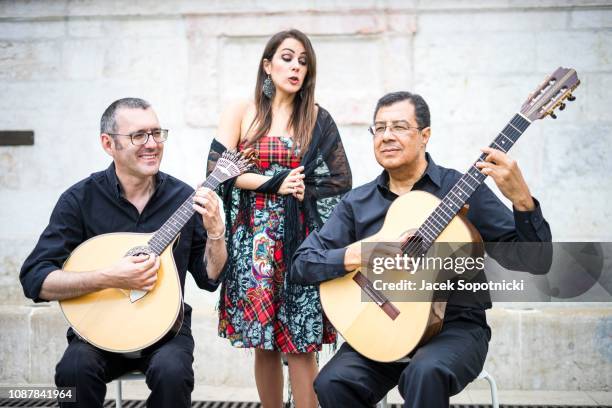 fado band performing traditional portuguese music on the square of alfama, lisbon, portugal - fado stock-fotos und bilder