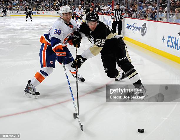 Eric Tangradi of the Pittsburgh Penguins battles for the puck against Jack Hillen of the New York Islanders on February 2, 2011 at Consol Energy...