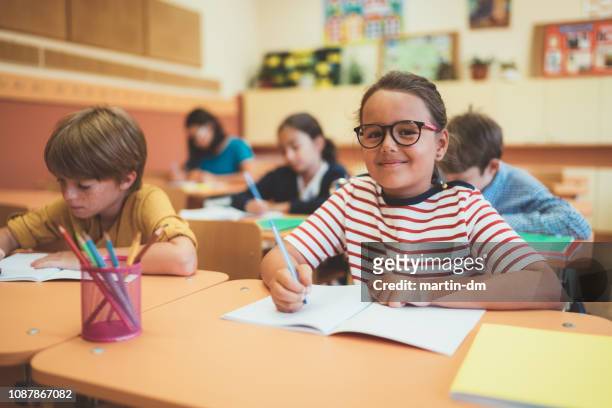 schoolgaande kinderen studeren in klasse - spelling stockfoto's en -beelden