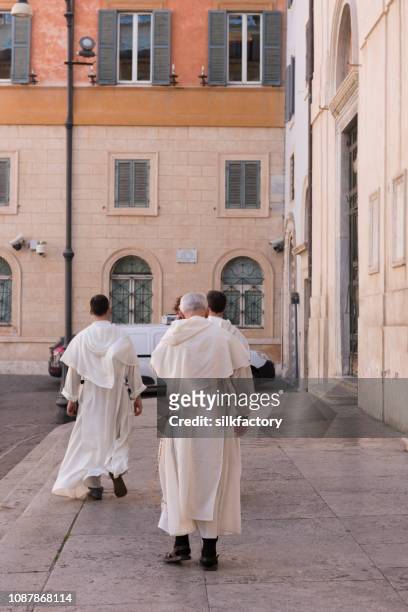 three catholic brothers walking together in rome - cleric stock pictures, royalty-free photos & images