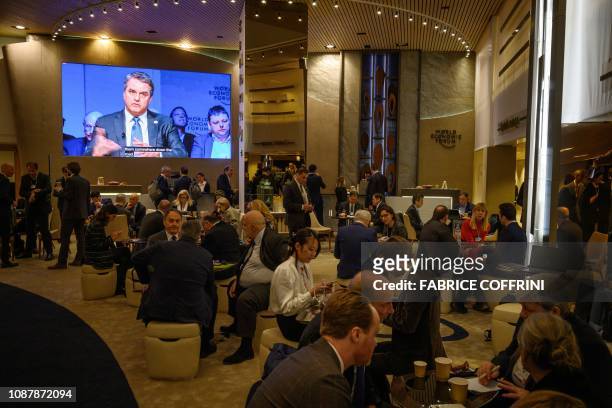 Director-General of the World Trade Organization Roberto Azevedo is seen on a giant screen in the lobby of Congress centre during the World Economic...