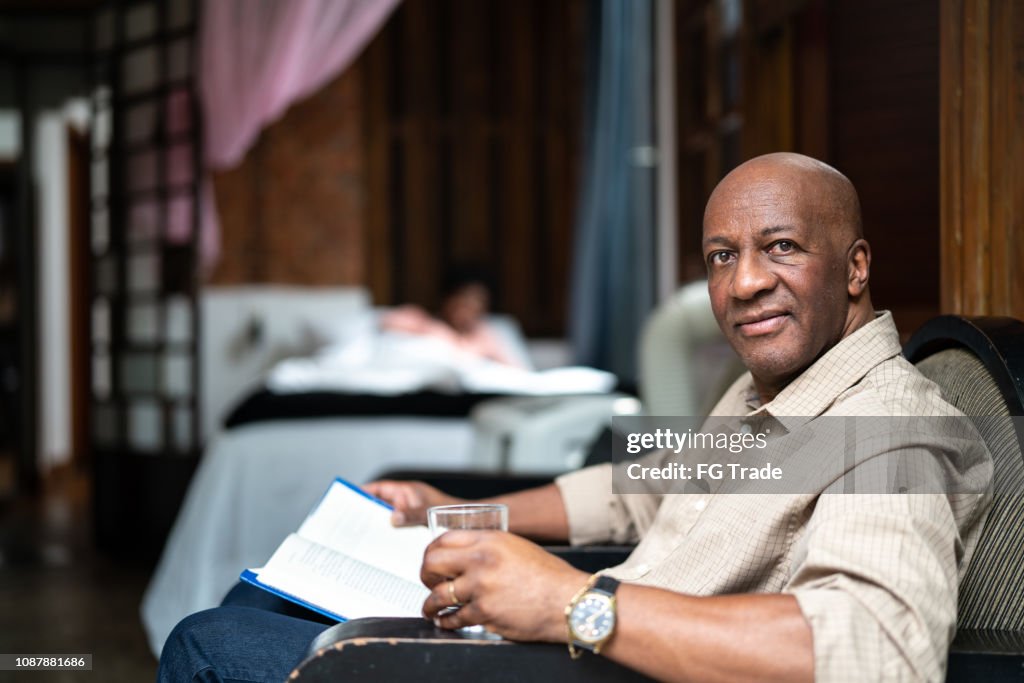 Afro Mature Man Reading a Book at Home