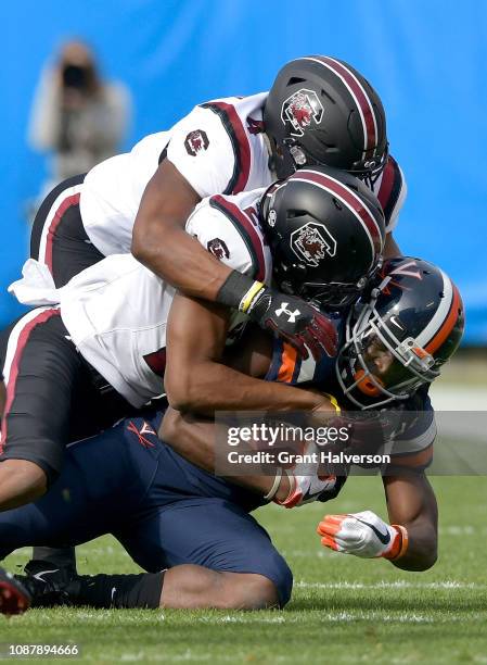 Bryson Allen-Williams and Israel Mukuamu of the South Carolina Gamecocks tackle Olamide Zaccheaus of the Virginia Cavaliers during the first half of...