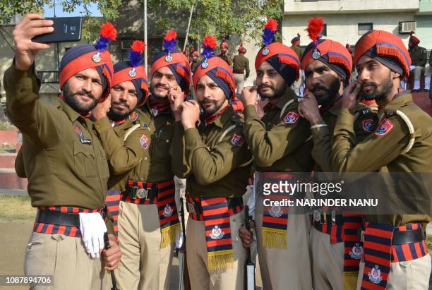 Indian Punjab police personnel take selfies during a full dress rehearsal for the upcoming 70th Republic Day parade in Amritsar on January 24, 2019....