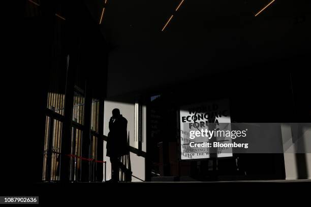 An attendee talks on his mobile phone inside the congress center on day three of the World Economic Forum in Davos, Switzerland, on Thursday, Jan....