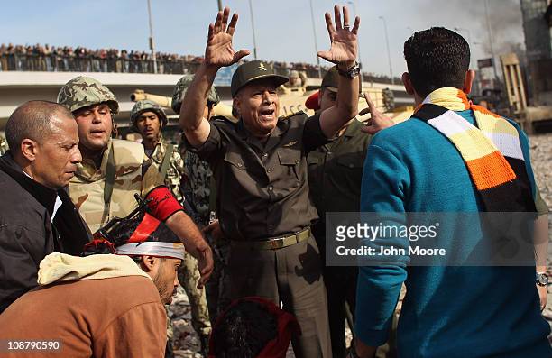 An Egyptian army officer urges anti-government demonstrators to move back on February 3, 2011 in Cairo, Egypt. The Army positioned tanks between the...
