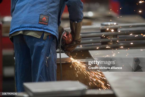 January 2019, Saxony-Anhalt, Magdeburg: An employee of Stahlbau Magdeburg processes a workpiece with a grinding machine. At noon the Prime Minister...