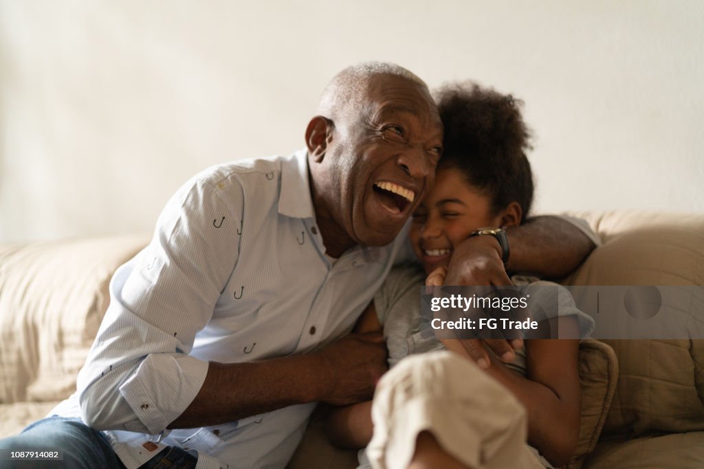 Grandfather Playing with Her Granddaughter at Home