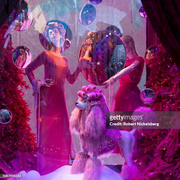 Pedestrians and tourists have their pictures taken near the Broadway themed Theater of Dreams shop windows at Saks Fifth Avenue department store in...