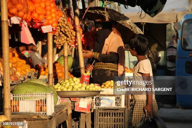 Veiled Muslim woman buys fruits in Maungdaw town market in the restive Rakhine state on January 24, 2019. Maungdaw was the epicentre of a brutal...