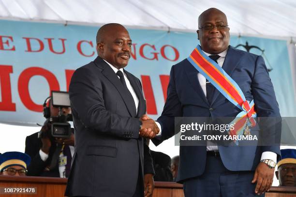 Democratic Republic of the Congo's outgoing President Joseph Kabila shakes hands with newly inaugurated President Felix Tshisekedi on January 24,...