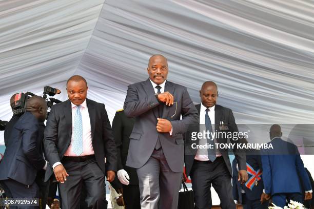 Democratic Republic of the Congo's outgoing President Joseph Kabila walks off the podium on January 24, 2019 after he officially handed over the...