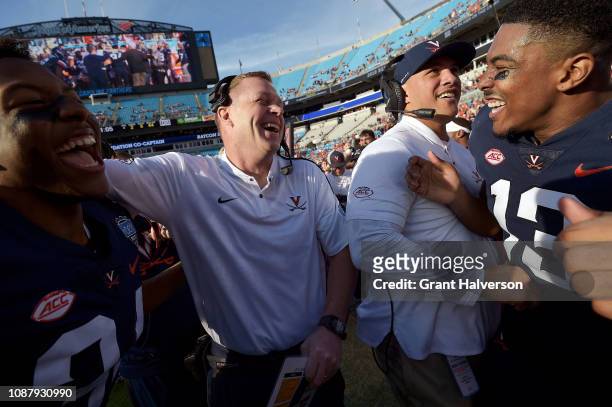 Head coach Bronco Mendenhall of the Virginia Cavaliers celebrates with his team after a win against the South Carolina Gamecocks during the Belk Bowl...