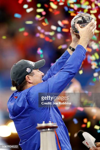 Head coach Dan Mullen of the Florida Gators hold the trophy after his teams win over the Michigan Wolverines during the Chick-fil-A Peach Bowl at...