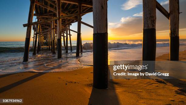 sunset beneath the pier - newport beach california fotografías e imágenes de stock