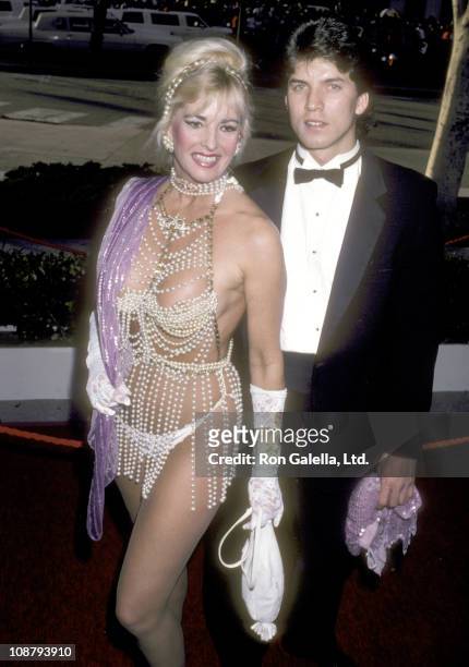 Actress Edy Williams and date attend the 58th Annual Academy Awards on March 24, 1986 at Dorothy Chandler Pavilion in Los Angeles, California.