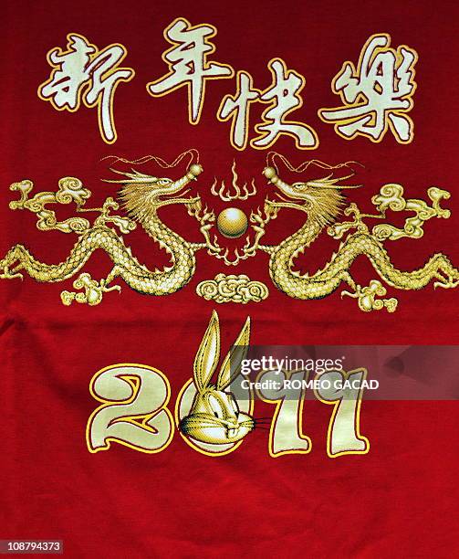 Red t-shirts designed with figures of two dragons and rabbit cartoon are sold at sidewalk shop in Glodok market in Jakarta's Chinatown on February 3,...