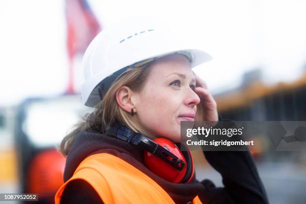 portrait of a woman on a construction site - bauingenieur stock-fotos und bilder