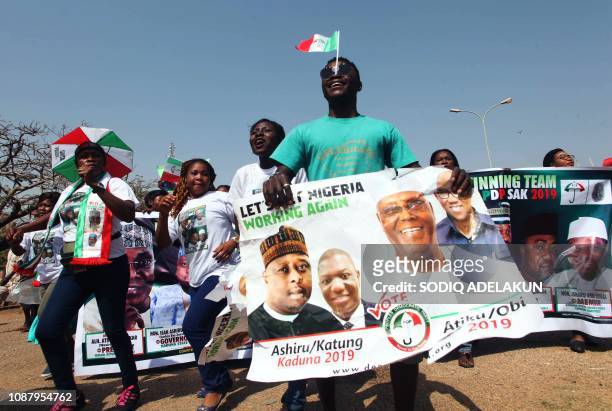 Supporters of Nigerian opposition presidential candidate of the People's Democratic Party Atiku Abubakar hold his portrait during a campaign rally at...