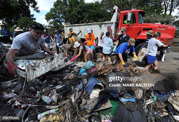 Local residents and volunteers remove flood debris from homes in the Brisbane suburb of Fairfield on January 16, 2011. An army of volunteers turned...