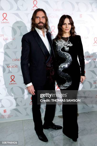 French hair stylist John Nollet and French actress Juliette Binoche pose during a photocall upon arriving to attend the "Diner de la Mode" fundraiser...