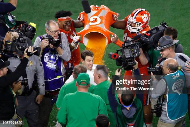 Head coach Dabo Swinney of the Clemson Tigers shakes hands with head coach Brian Kelly of the Notre Dame Fighting Irish as his players dump Gatorade...