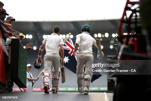 Nathan Lyon and Pat Cummins of Australia walk out to bat on day five of the Third Test match in the series between Australia and India at Melbourne...