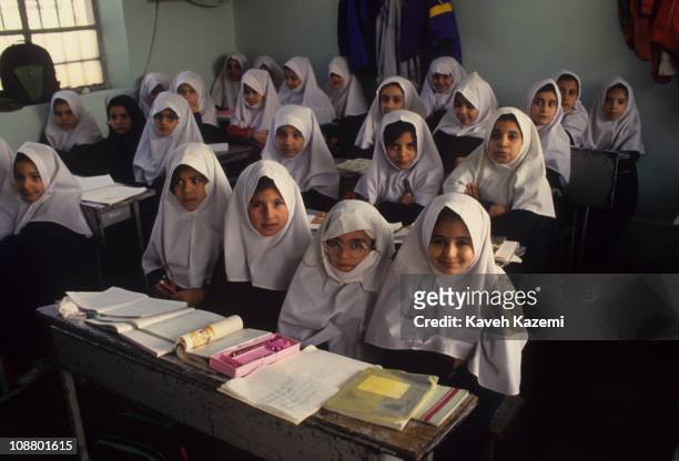 Primary school girls in traditional headscarves sit in a classroom, Tehran, Iran, October 1, 1997.