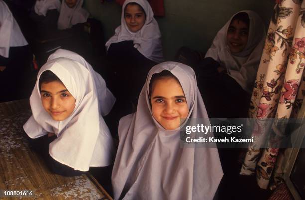 Primary school girls in traditional headscarves sit in a classroom, Tehran, Iran, October 1, 1997.