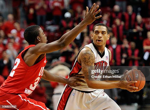 Anthony Marshall of the UNLV Rebels looks to pass against Shawn Glover of the Utah Utes during their game at the Thomas & Mack Center February 2,...