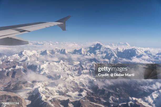 flying over the himalayas between nepal and tibet with the kangchenjunga mountain in the background - kangchenjunga stock-fotos und bilder