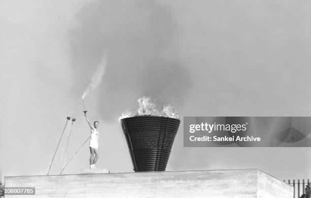 The final bearer of torch relay Yoshinori Sakai poses in front of the Olympic cauldron during the opening ceremony of the Tokyo Olympic at the...