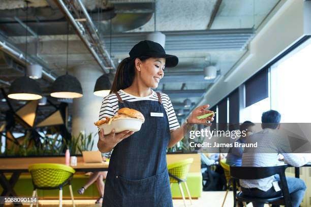 young waitress delivers food in restaurant - waitress foto e immagini stock