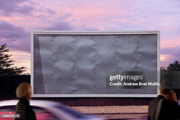 blank billboard with passing pedestrians - billboards stock-fotos und bilder