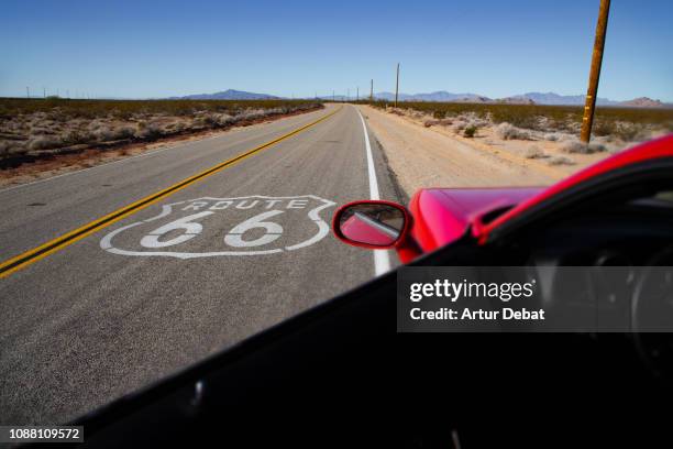 american car driving in a straight road of the famous route 66. - route 66 stock pictures, royalty-free photos & images