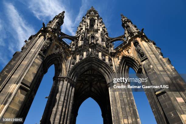 looking up to the soot stained stones of the sir walter scott monument of victorian gothic architecture in edinburgh scotland uk with blue sky - cidade nova edimburgo imagens e fotografias de stock