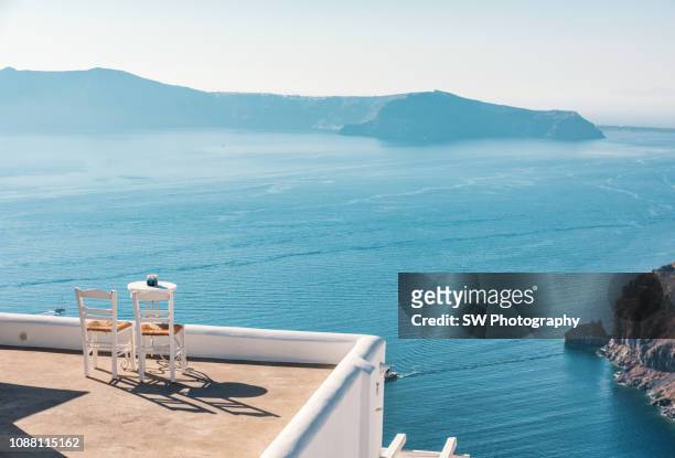 empty rooftop with chairs and desk in thira town, santorini - greece landscape stock pictures, royalty-free photos & images