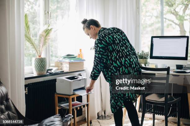 young businesswoman using computer printer at home office - impressora de computador imagens e fotografias de stock