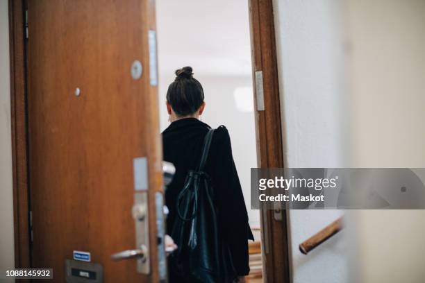 rear view of businesswoman entering at coworker's apartment - work arrival stock pictures, royalty-free photos & images