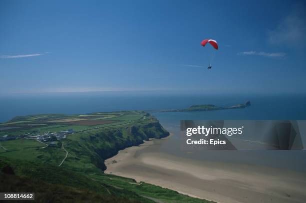 Paraglider enjoys spectacular views of the coastline at Rhossili, and the Gower Peninsula, Wales, June 1997.