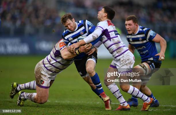 Will Chudley of Bath is tackled by Dan Cole and Ben Youngs of Leicester Tigers during the Gallagher Premiership Rugby match between Bath Rugby and...