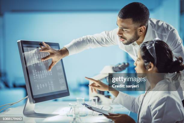 wetenschappers werken in het laboratorium, met behulp van touchscreen - biochemie stockfoto's en -beelden