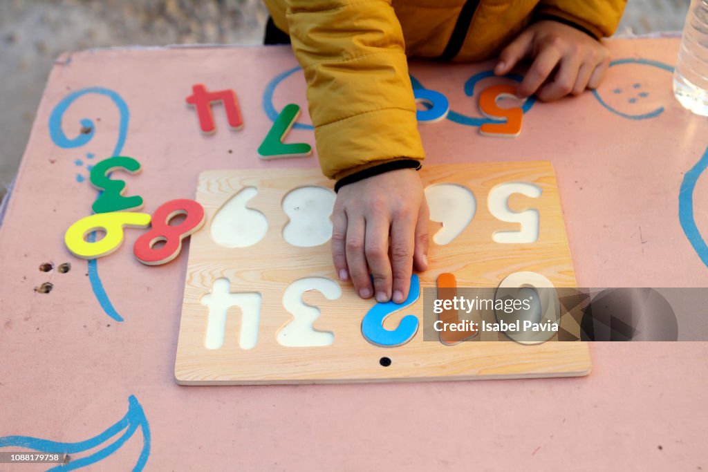 Boy Playing With Wooden Numbers Puzzle
