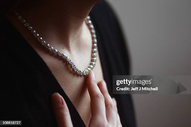 Sally Stevens, from Lyon & Turnbull poses with a diamond set riviere necklace on February 4, 2011 in Edinburgh, Scotland. The sale being held on the...